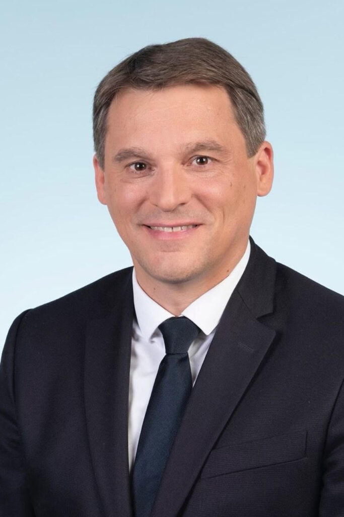 Un portrait de Nicolas Ray, député de la troisième circonscription de l’Allier. On voit son buste devant un fond bleu.