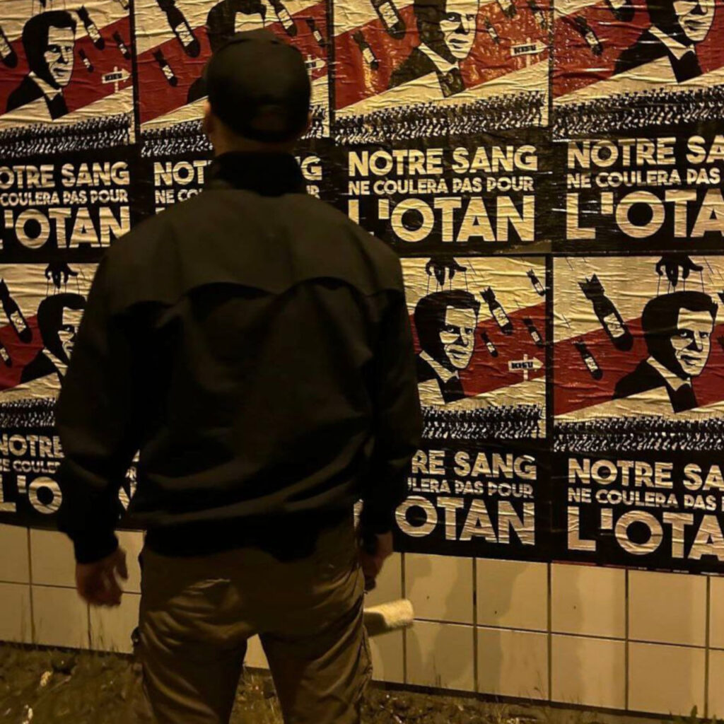 Un militant de CNC colle des affiches dans Clermont-Ferrand.