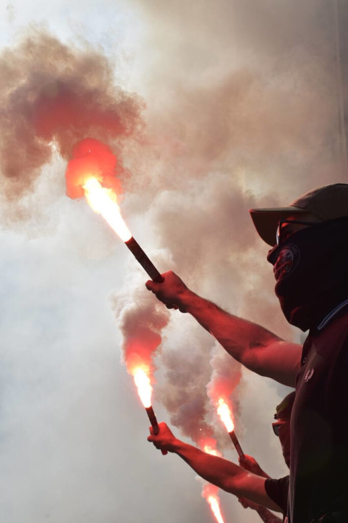 Des militants de CNC brandissent des fumigènes pendant une manifestation.