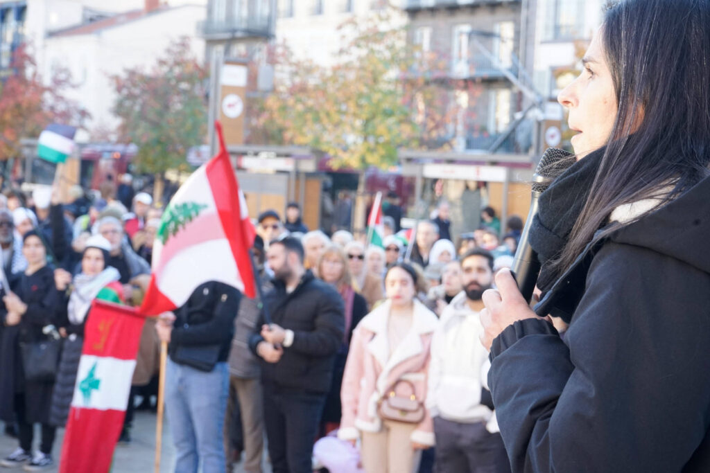 On voit ici la députée Marianne Maximi, prononcer un discours sur la place de Jaude.