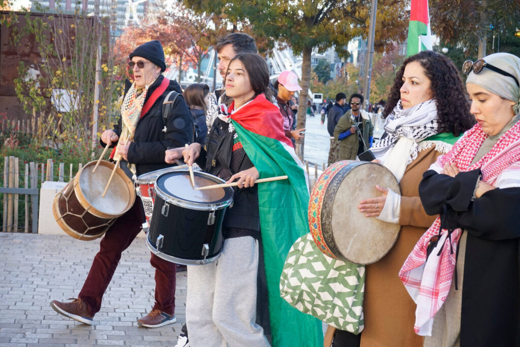 On voit ici la tête du cortège, avec les musiciens jouant exclusivement des percussions. Tous ont un keffieh, et l’une d’entre eux est même habillée d’un drapeau palestinien.