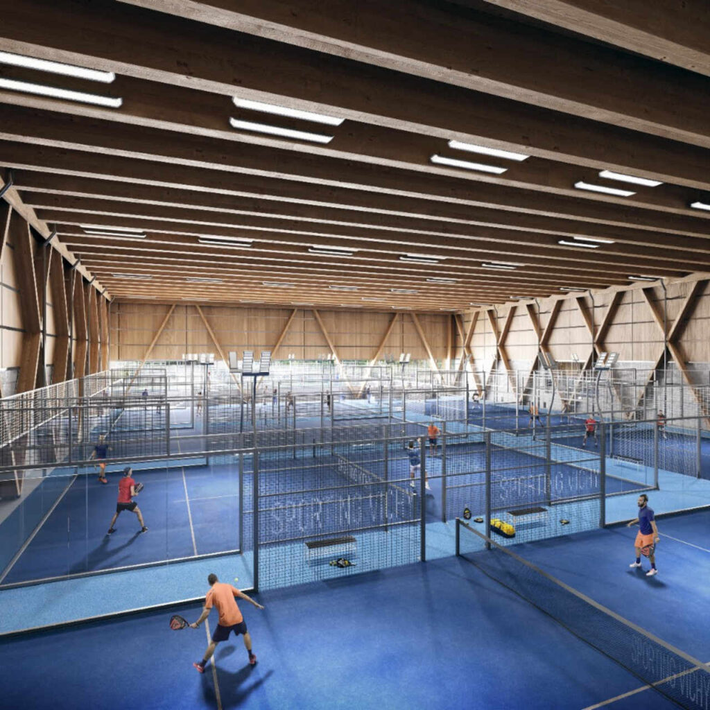 Pistes de padel intérieures dans un gymnase avec joueurs jouant dessus.