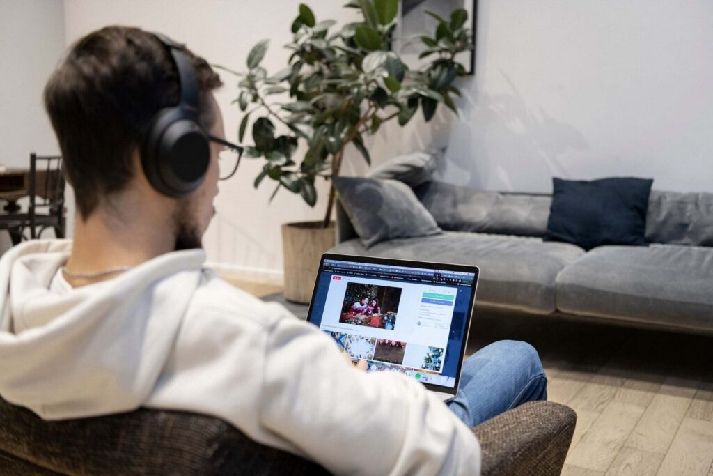 Un jeune homme, de dos, utilise son ordinateur pour s’informer sur les réseaux sociaux. 